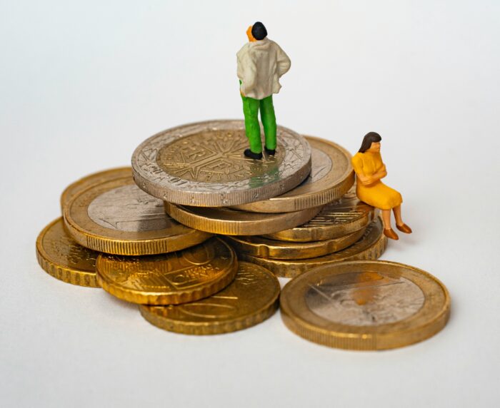 An image of coins with people sat on them.